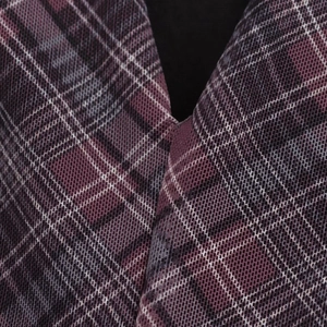 Detalle del escote en V de un vestido de tul plisado con cuadros morados tejidos