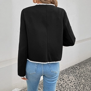 Rear view of black waffle knit jacket featuring white wavy contrast trim and cropped cut