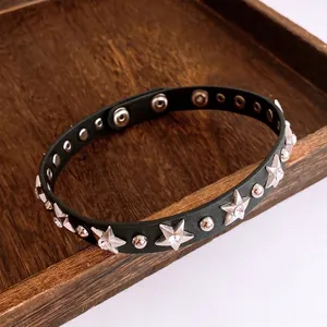 Black leather punk choker with silver star studs and rhinestones on wood tray