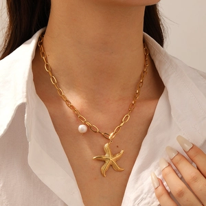 Gold plated stainless steel necklace featuring a starfish pendant and white pearl on model