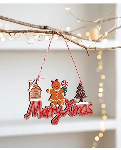 Close-up of wooden Merry Xmas tag with gingerbread man and tree hanging on a branch