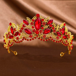 Macro detail of luxury baroque gold tiara with red crystals and intricate floral patterns