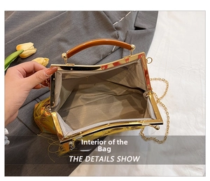 Detail view of yellow embroidery handbag with amber handle and gray herringbone lining