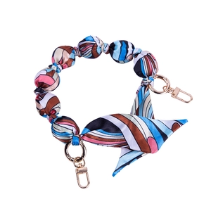 Close-up of geometric pattern silk twisted bag strap with gold metal lobster clasps