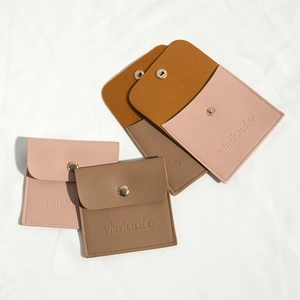 Detail of PU leather jewelry pouches with snap button closure in pink, tan and brown
