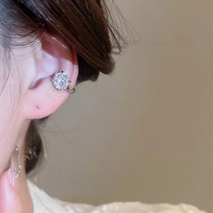 Close-up of a silver non-pierced ear cuff featuring a large sparkling round zircon stone