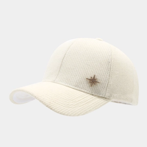 Detail of beige corduroy baseball cap texture with a gold star metal accent