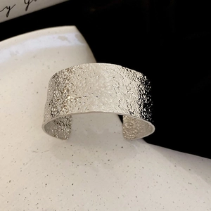 Detail of silver hammered texture open cuff bracelet with minimalist metallic finish