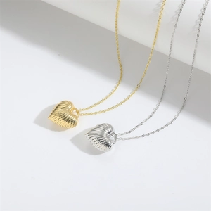 Detail of vintage striped heart pendants in gold and silver finish on white steps
