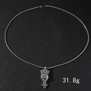 Gros plan d'un pendentif tête de lion avec couronne et croix, 31,8g sur fond noir