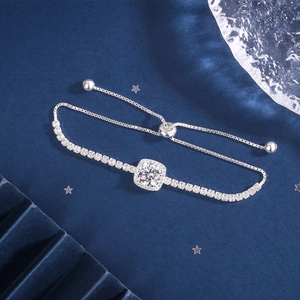 Detail of adjustable silver tennis bracelet with square zircon on blue velvet