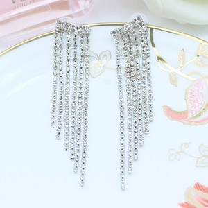 Eleganti orecchini a nappa a cascata d'argento con strass su piatto decorativo in ceramica