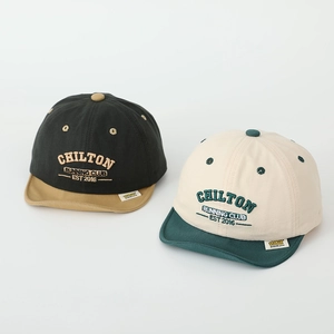 Détail de casquettes de baseball en coton pour bébé avec broderie bouclée et étiquette jaune