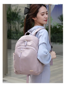 Mochila rosa de tela oxford en modelo con diseño moderno y varios bolsillos con cremallera