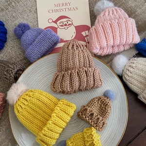 Mini knitted Christmas hats set in colorful yarn for festive holiday tree decorations