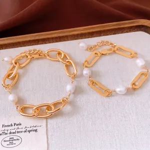 18k gold plated chain bracelets with white pearls on a rustic wooden display tray