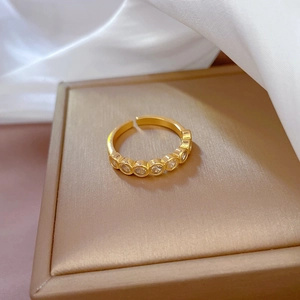 Detail of adjustable gold-plated ring with sparkling pavé cubic zirconia on satin