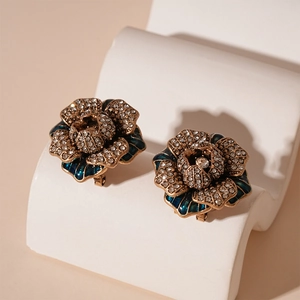 Macro detail of vintage floral earrings with blue enamel petals and sparkling rhinestones