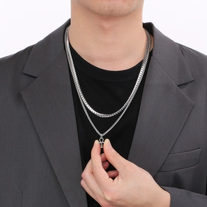 Detail of silver double-layered necklace with Ankh cross pendant worn on a male model