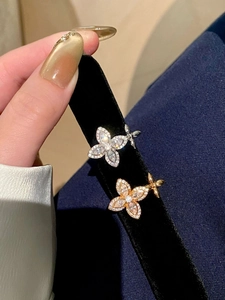 Close-up of gold and silver butterfly rings with sparkling cubic zirconia on black velvet