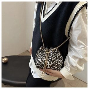 Detail of leopard print bucket bag with gold chain strap and pearl drawstring tassels