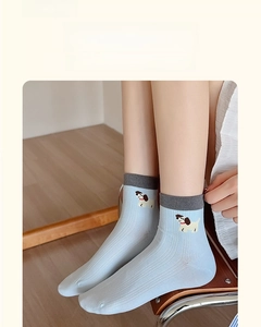 Detail of light blue cotton sock with ribbed texture and cute puppy pattern for women