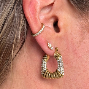 Macro view of 18K gold plated geometric trapezoid earrings with inlaid zircons on ear