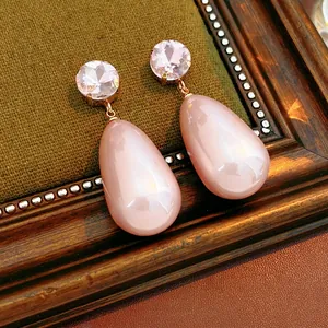 Elegant gold drop earrings featuring pink teardrop gemstones and sparkling round crystals