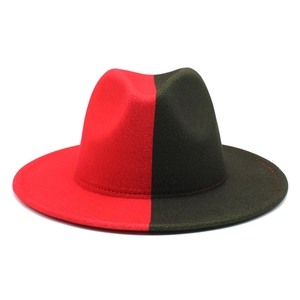 Détail d'un chapeau fedora bicolore rouge et vert olive avec large bord plat et texture lisse