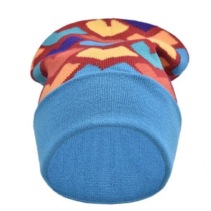 Detail of colorful rainbow knit beanie featuring vibrant geometric waves and blue ribbed cuff
