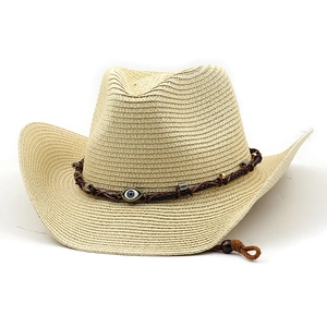 Classic straw cowboy hat in beige with western band and evil eye charm on white background