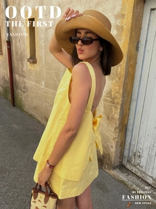 Detail of summer yellow backless top with bow knot and matching skirt in resort style