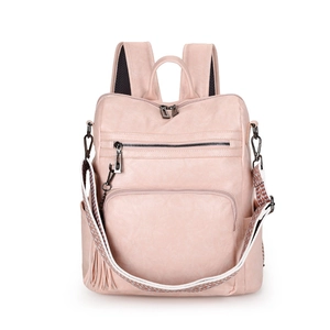 Close-up of pink leather backpack with fringe tassel and woven strap detail