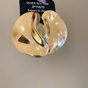 Detailed view of large gold liquid metal 925 silver irregular fluid drop earrings
