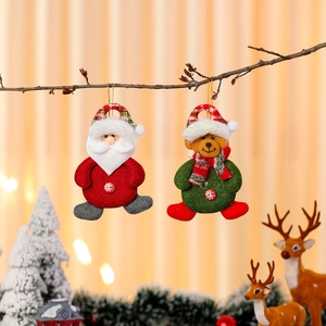 Festive Santa and scarf bear fabric ornaments hanging on branches with warm bokeh lights