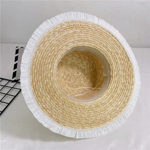 Straw sun hat with frayed fringe edges and pearl accents for summer beach vacation wear