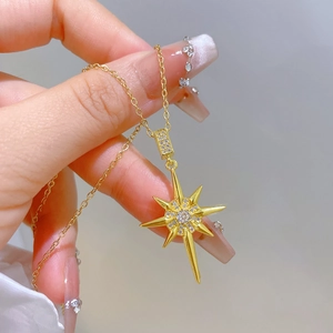 Close-up of golden starburst necklace with sparkling crystals on fine O-chain