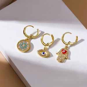 Golden hoop earrings set with zircon evil eye and Hamsa hand charms for multi-piercings