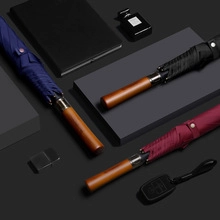 Detail of premium business umbrellas with walnut wood handles in blue, black, and burgundy