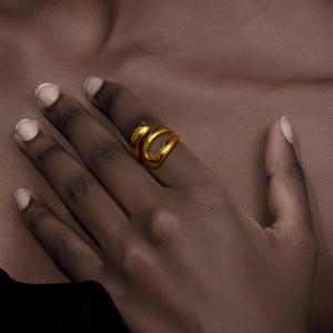 Detail of a 18K gold plated triple layered snake ring with fluid organic design on finger
