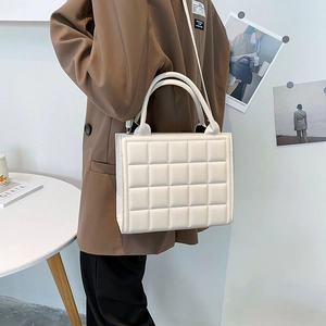 Fashionable cream quilted square handbag with structured cross pattern and top handle