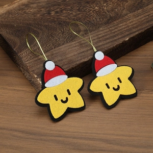 Detailed view of yellow felt star ornament with Christmas hat on wood background