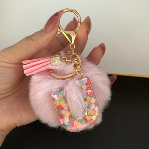 Pink plush pom pom U-letter keychain with tassel and glitter heart resin detail