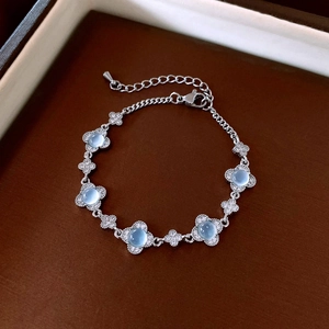 Dettaglio macro del bracciale a quadrifoglio con pietre blu e zirconi in stile francese