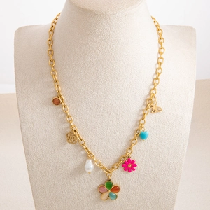 Detail of gold chain necklace featuring colorful enamel flowers and butterfly charms