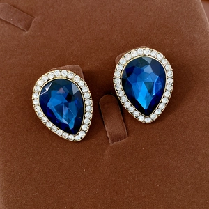 Vue rapprochée des boucles d'oreilles vintage saphir bleu et zircons en boîte velours
