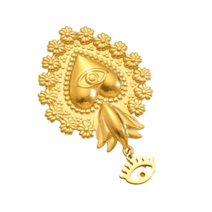 Macro shot of golden Sacred Heart pendant with eye relief and ornate floral details