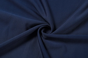Detailed close-up of dark blue elastic knit fabric with premium texture and drape