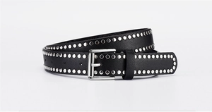 Detailed close-up of a black PU leather belt with silver punk studs and metal pin buckle