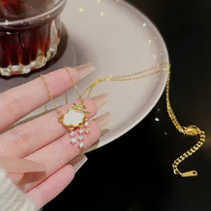 Detail of gold cloud necklace with zircon accents and sparkling rhinestone tassels